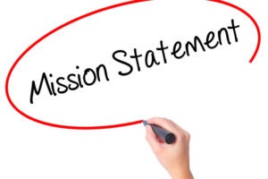Women Hand writing Mission Statement with black marker on visual